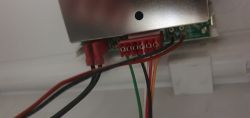 Zbliżenie na podłączenie przewodów do czerwonej złączki na płytce elektronicznej urządzenia.