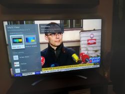 Ekran telewizora z funkcją Multi View i programem informacyjnym w tle