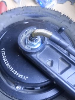 Zbliżenie na tylną oponę hulajnogi Motus Pro 10 z widocznym przewodem zasilającym silnik.