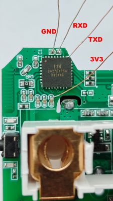 Close-up of a circuit board with labeled pins GND, RXD, TXD, and 3V3 on the T34 chip.