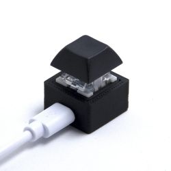 Jednoprzyciskowy przycisk USB w czarnym obudowie z podłączonym białym kablem USB.