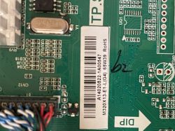Section of a green printed circuit board with electronic components, barcode, and TP.S label.