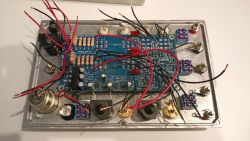 Zdjęcie wnętrza przystawki do pomiaru wzmacniaczy audio z widocznymi elementami elektronicznymi.