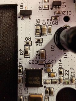 Close-up of a PCB with SMD parts and labels R, C, U, plus a large electrolytic capacitor