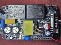 Close-up of a circuit board with relays, capacitors, and a transformer.
