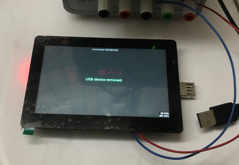 Touchscreen board displays “USB device removed” and an IP address; a USB plug lies beside it