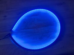 Semi-circular blue LED strip on a wooden floor.