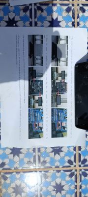Photo of module installation instructions with several device images, laying on a tiled background.