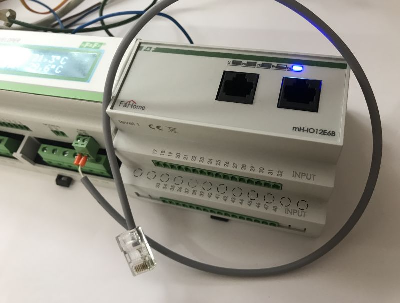 F&amp;Home mH-IO12E6B home automation module with visible ports and a connected network cable.