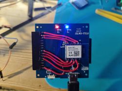 Circuit board with red and blue LEDs, button, and wired connections.