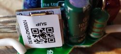 Close-up of Electronic Module with QR Code Close-up of an electronic module with a sticker containing a QR code and a numerical barcode.