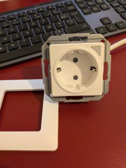 Wall Socket Without Power Monitoring Module View of a white wall socket against a keyboard background.