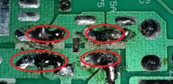Zbliżenie na płytkę PCB z czterema punktami lutowniczymi zaznaczonymi czerwonymi obwódkami