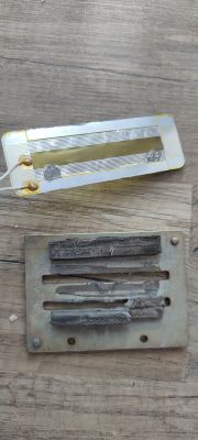 Zniszczone elementy elektroniczne z widocznymi uszkodzeniami i popękanymi magnesami.