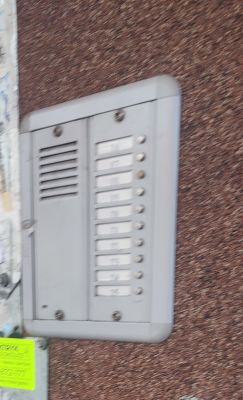 Domofon z przyciskami na ścianie budynku.