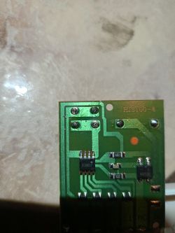 Zbliżenie na zieloną płytkę PCB z widocznymi ścieżkami i elementami elektronicznymi