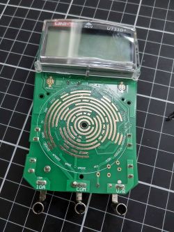 Disassembled UNI-T UT33D+ multimeter showing the circuit board.