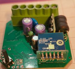 Image of an electronic module with a green terminal block and various components.