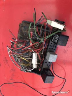 Skupisko przewodów i elementów elektronicznych na czerwonym tle.