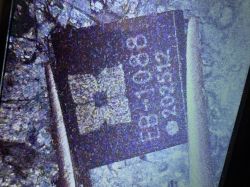 Close-up of a purple label with a code-like white print on a rough surface