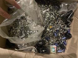 Pudełko wypełnione różnymi częściami elektronicznymi jak tranzystory, kondensatory i scalaki.