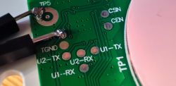 Close-up of a circuit board with test point labels and wires at solder joints.