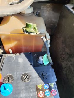 Zdjęcie akumulatora samochodowego z klemami i nakrętką.