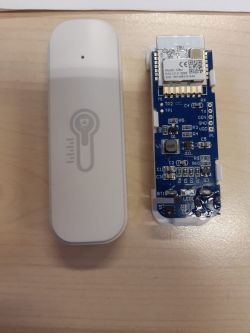 Electronic sensor disassembled into parts, showing PCB and casing.