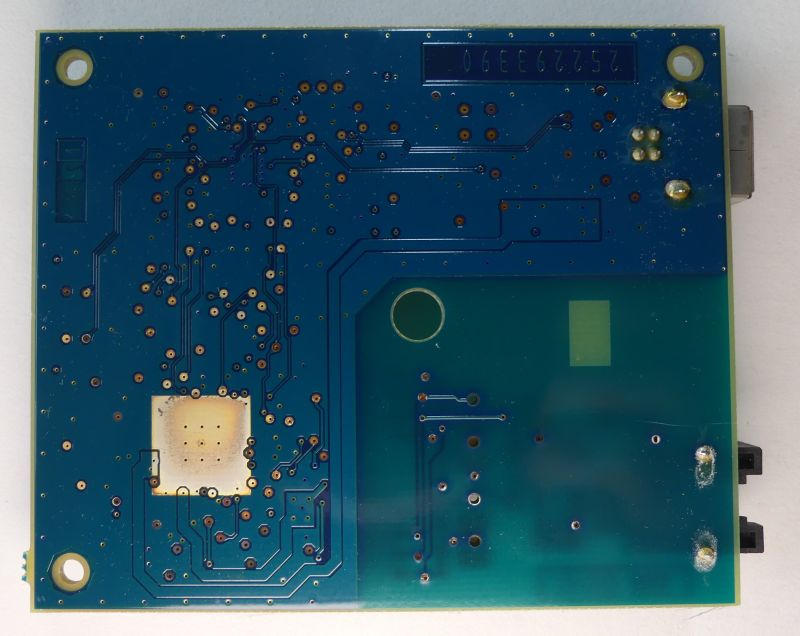 Spód płytki drukowanej PCB z widocznymi ścieżkami i otworami montażowymi.