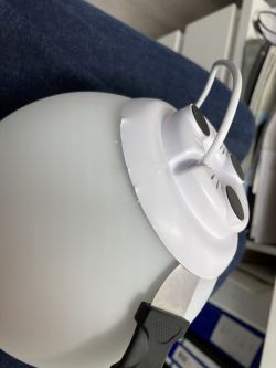 A tool wedged between the base and the glass bulb of a lamp.