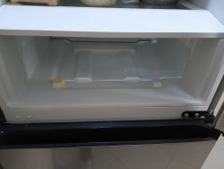Widok wnętrza lodówki Samsung z zauważalnym pęknięciem plastiku pod szufladą no frost.