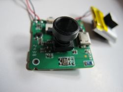 Electronic camera module on a PCB Camera module on a green PCB with visible electronic components.