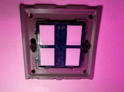 Front panel with touch buttons mounted on a wall with purple lighting.