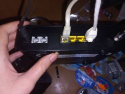 Widok tylnego panelu routera z podłączonymi kablami zasilania i Ethernet