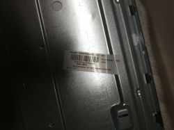A sticker with model number and details on a TV's metal casing.