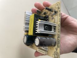 Osoba trzymająca płytkę elektroniczną z różnymi komponentami.