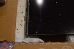 Telewizor Samsung z uszkodzoną obudową i matrycą w kartonie.