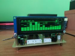 LCD module showing a green spectrum analyzer bar graph on an electronic circuit board on a desk