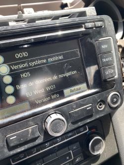 Close-up of a car navigation system screen showing version info and buttons labeled NAV, TRAFFIC, SETUP.