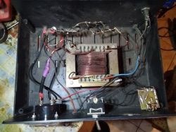 Wnętrze prostownika z widocznymi elementami elektrycznymi i przewodami.