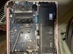 Wnętrze otwartego laptopa z widoczną płytą główną, akumulatorem i podzespołami elektronicznymi.