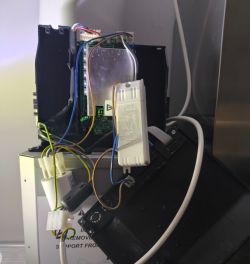 Widok wnętrza okapu Electrolux z wysuniętą elektroniką i okablowaniem.