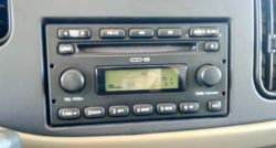 Konsola radioodtwarzacza Ford Econoline z wyświetlaczem LCD i przyciskami sterującymi.