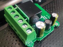Close-up of a PCB with electronic components, including a 22-ohm NTC and capacitors.