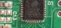 ESP8285 Chip on PCB Close-up of an ESP8285 chip mounted on a green PCB circuit board.