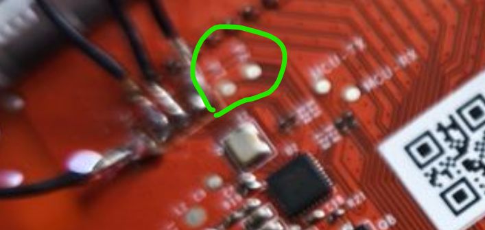 Close-up of a PCB with four pads circled in green marker