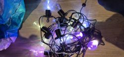Tangled decorative lights with colorful bulbs on a wooden floor.