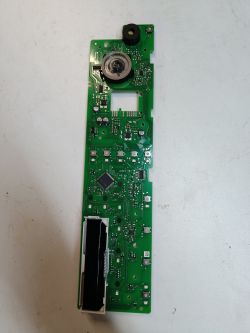Zielony moduł elektroniczny z układem scalonym i różnymi komponentami na białym tle.