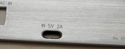 Close-up of a panel with a charging port and the label IN 5V 2A.