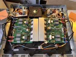 Wnętrze płyty indukcyjnej pokazujące elektronikę i zasilacze po odkręceniu obudowy.